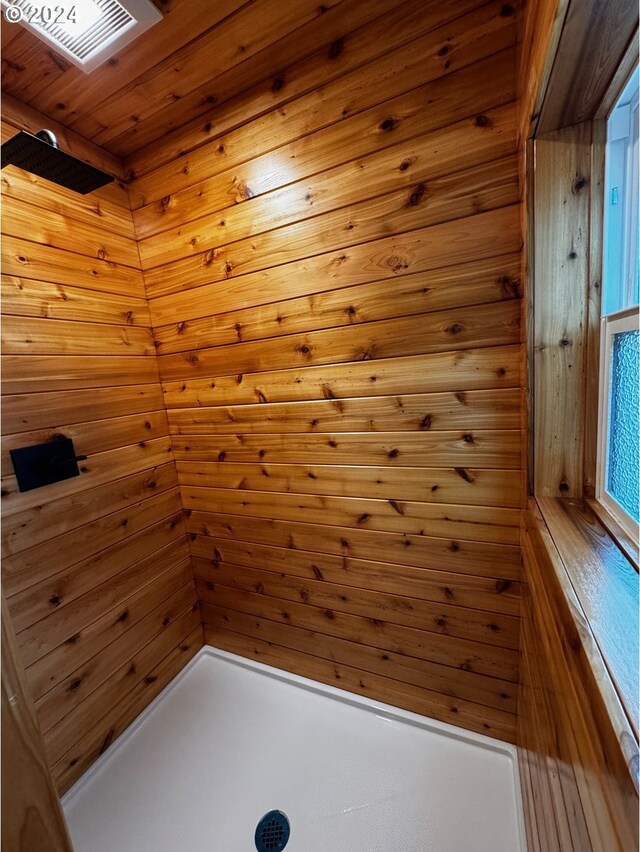 interior space with wood ceiling, wooden walls, and a skylight