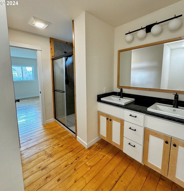 bathroom with a shower with door, vanity, and hardwood / wood-style floors