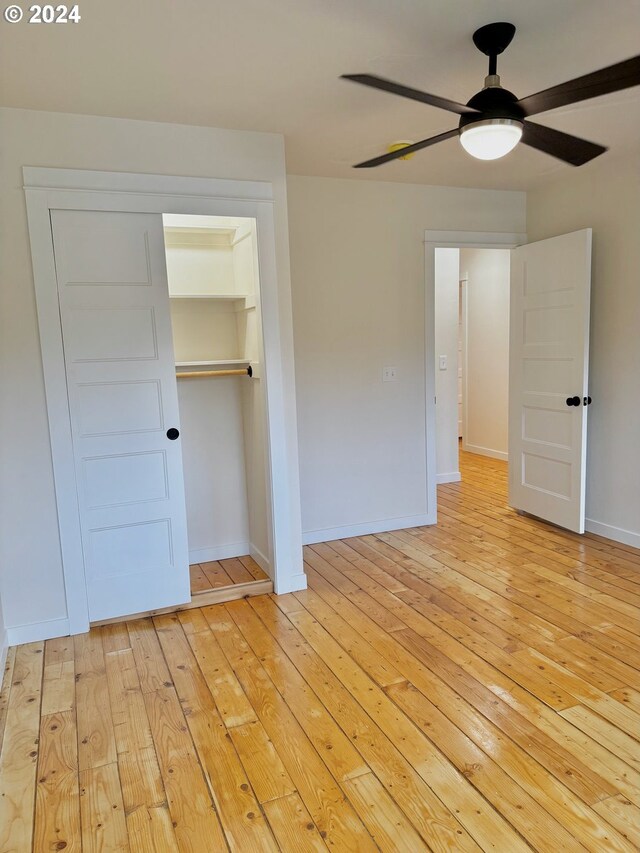 unfurnished bedroom featuring a closet, light wood-type flooring, and ceiling fan