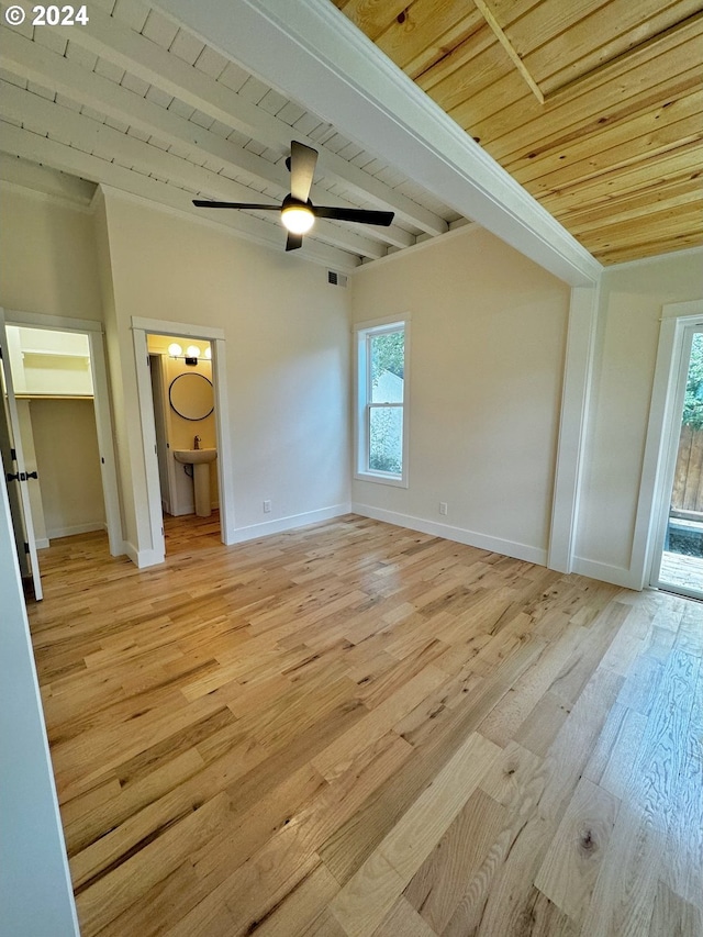 unfurnished bedroom featuring multiple windows, ensuite bathroom, wooden ceiling, and light wood-type flooring