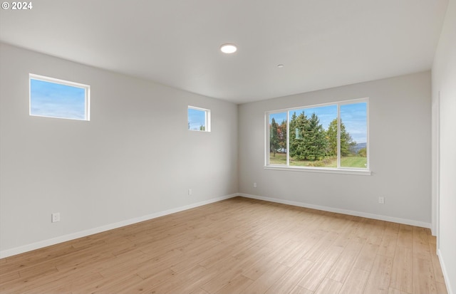 unfurnished room featuring baseboards, a healthy amount of sunlight, and light wood-style floors