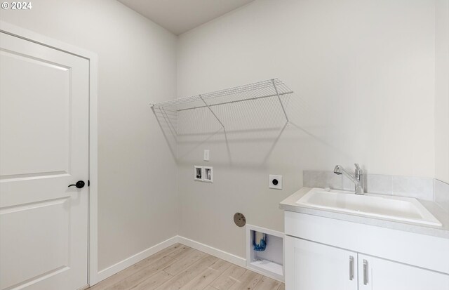 clothes washing area featuring hookup for a washing machine, light wood-style flooring, a sink, cabinet space, and electric dryer hookup