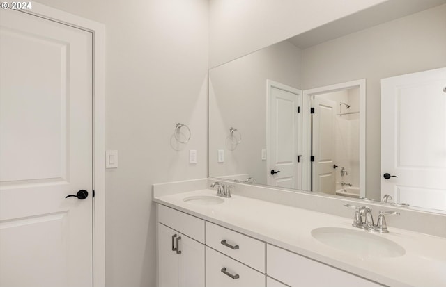 full bathroom with shower / bath combination, double vanity, and a sink