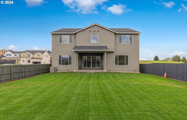 back of house with a yard, a fenced backyard, a residential view, and central air condition unit