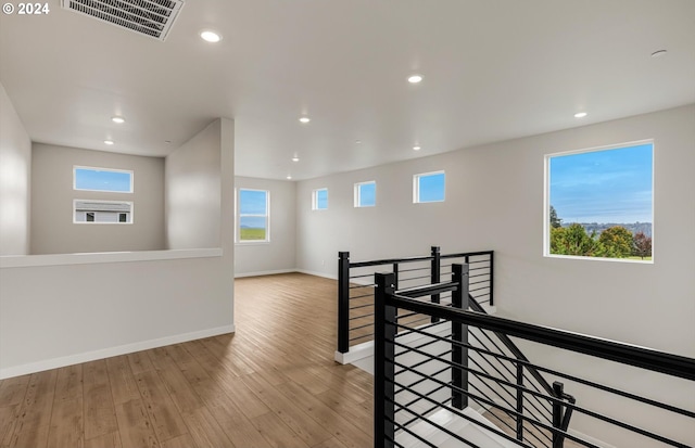 hallway featuring recessed lighting, visible vents, an upstairs landing, light wood-type flooring, and baseboards