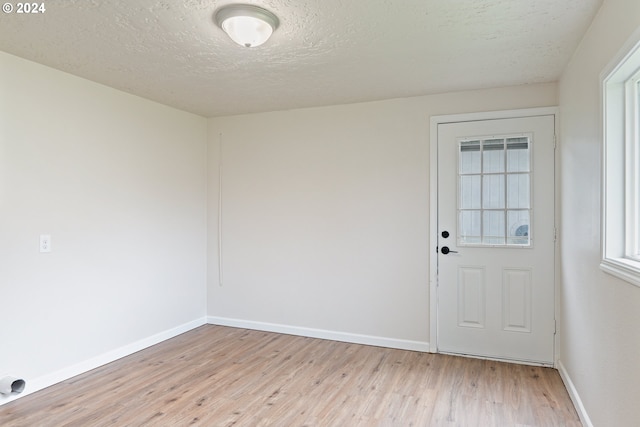 interior space featuring light hardwood / wood-style floors and a textured ceiling