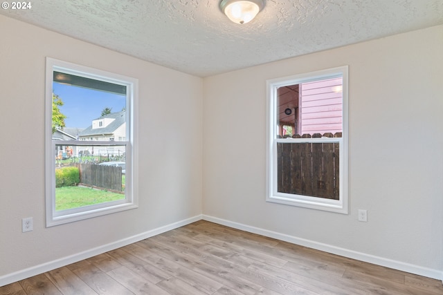 spare room with light hardwood / wood-style flooring and a textured ceiling