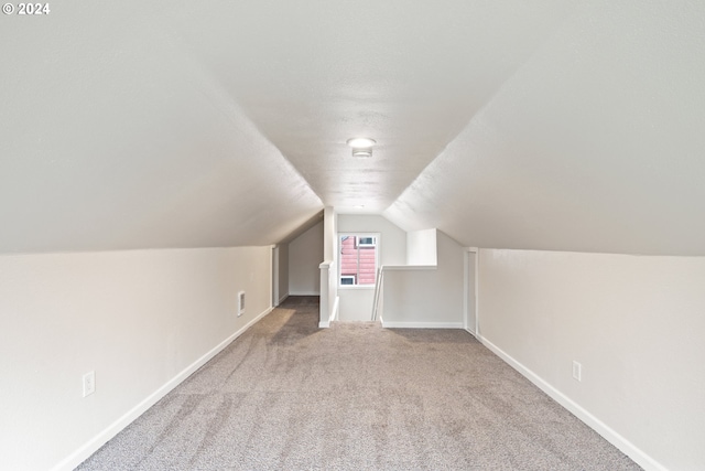 additional living space featuring carpet and lofted ceiling