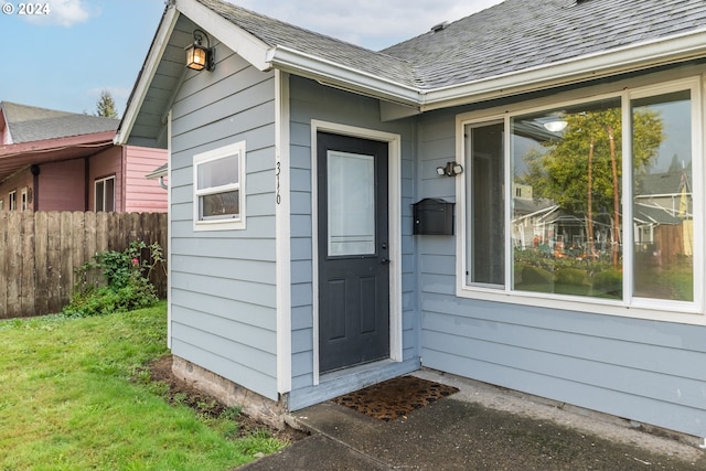 view of exterior entry with a lawn