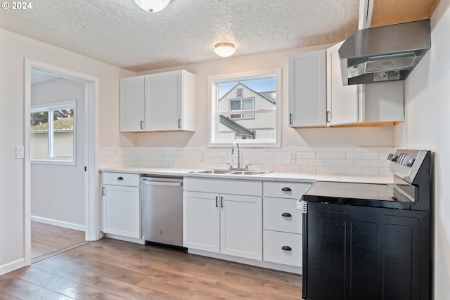 kitchen with a wealth of natural light, dishwasher, white cabinets, and range hood