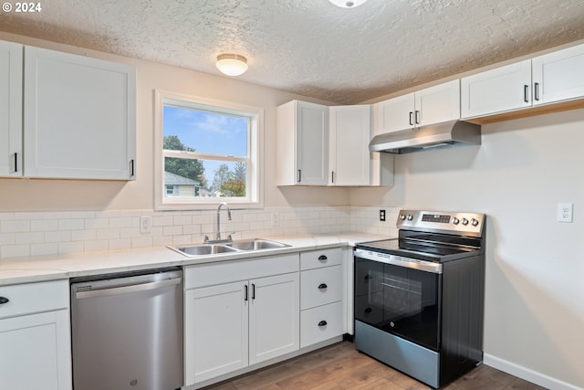 kitchen with appliances with stainless steel finishes, white cabinetry, and sink