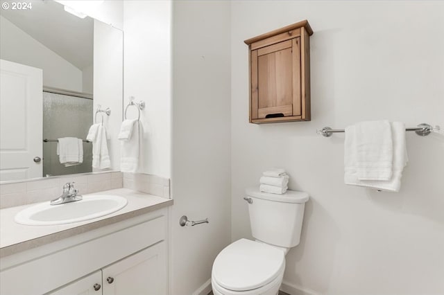 bathroom with vaulted ceiling, a shower with door, vanity, and toilet