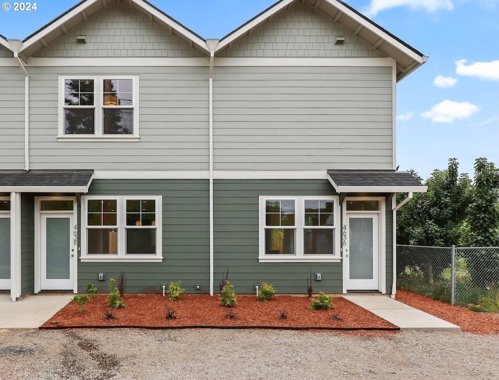 view of front of house featuring roof with shingles and fence