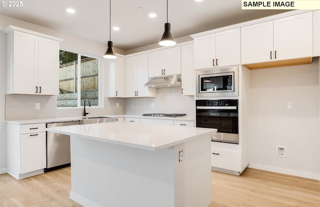 kitchen featuring stainless steel appliances, a center island, and white cabinets