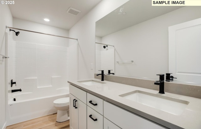 full bathroom featuring hardwood / wood-style flooring, vanity, toilet, and shower / bathing tub combination