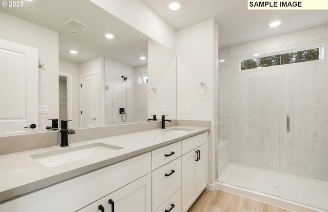 bathroom with vanity, hardwood / wood-style flooring, and a shower with shower door