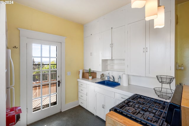 kitchen featuring white cabinets, white fridge, black range, and sink