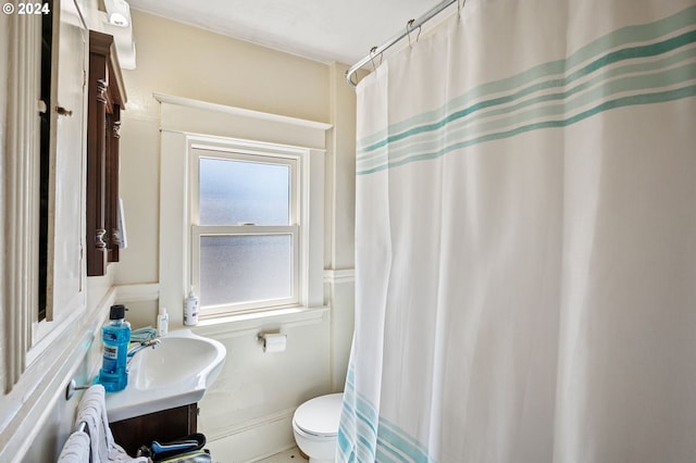 bathroom featuring a shower with shower curtain, vanity, and toilet