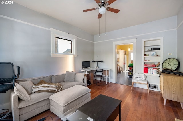 living room featuring dark hardwood / wood-style floors, ceiling fan, and built in features