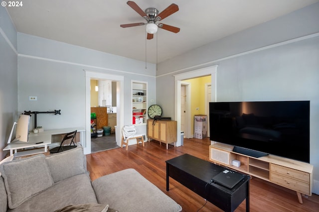 living room featuring built in shelves, ceiling fan, and hardwood / wood-style flooring