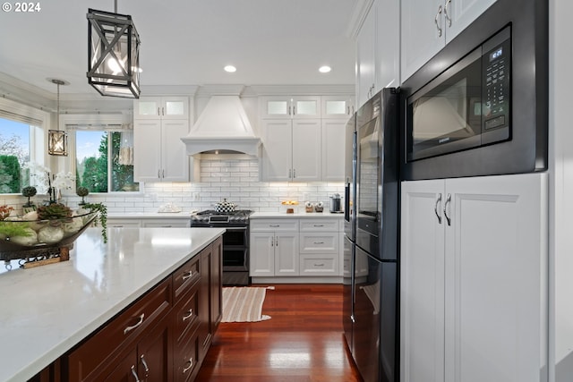 kitchen featuring white cabinetry, premium range hood, and appliances with stainless steel finishes