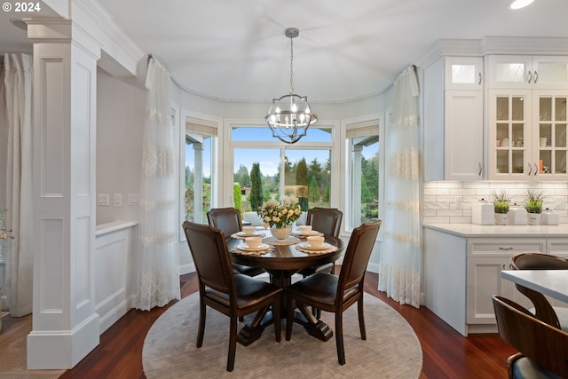 dining area featuring crown molding, dark wood-type flooring, and a notable chandelier