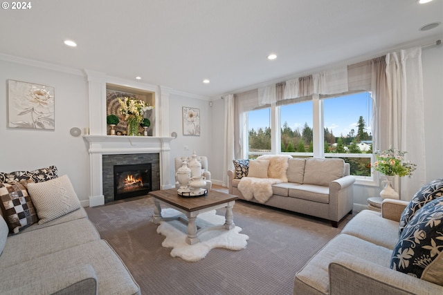 living room featuring a tile fireplace, ornamental molding, and a wealth of natural light