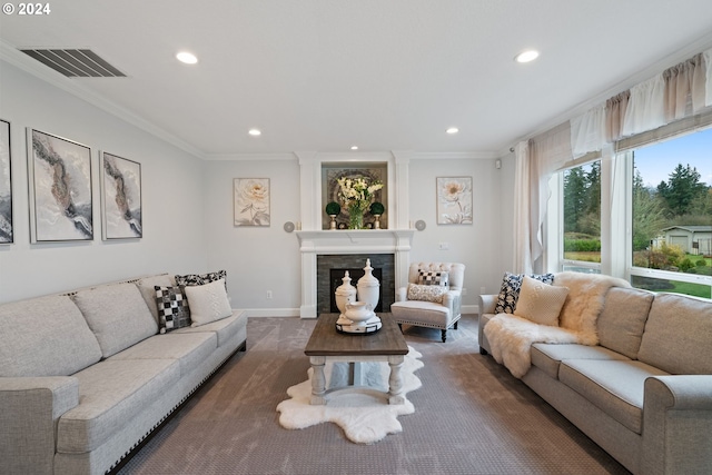 living room with a tiled fireplace and crown molding