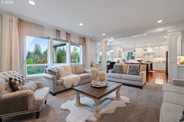 living room with decorative columns and light hardwood / wood-style flooring