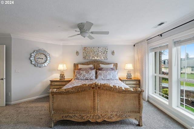 carpeted bedroom with ceiling fan, ornamental molding, and a textured ceiling