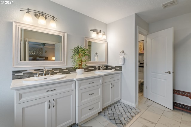 bathroom featuring decorative backsplash, vanity, a textured ceiling, and toilet