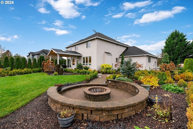 back of property with a yard and an outdoor fire pit