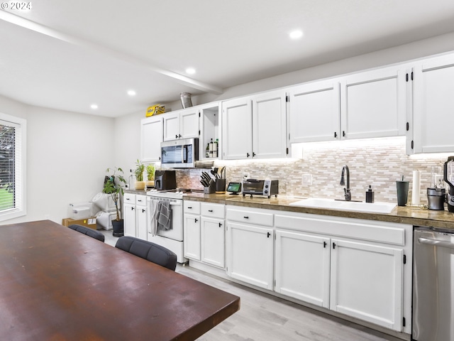 kitchen featuring light wood-type flooring, stainless steel appliances, backsplash, sink, and white cabinets