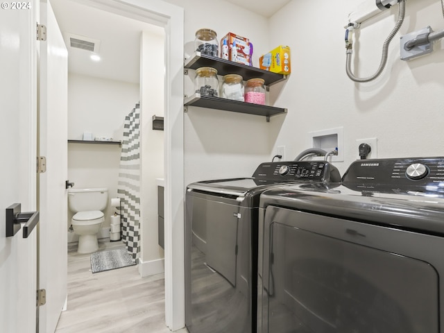 laundry room with electric dryer hookup, light wood-type flooring, and washing machine and dryer