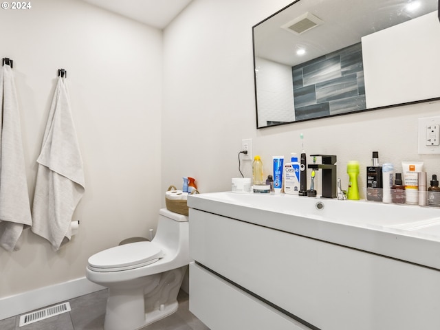 bathroom with toilet, vanity, and tile flooring