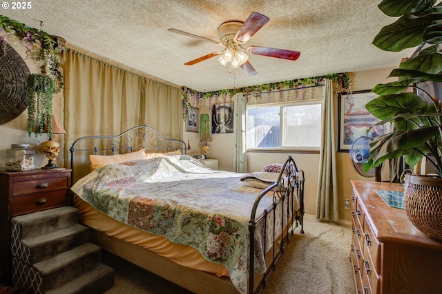 bedroom with ceiling fan, light carpet, and a textured ceiling