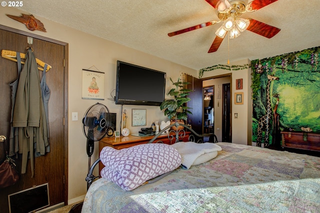 bedroom with ceiling fan and a textured ceiling