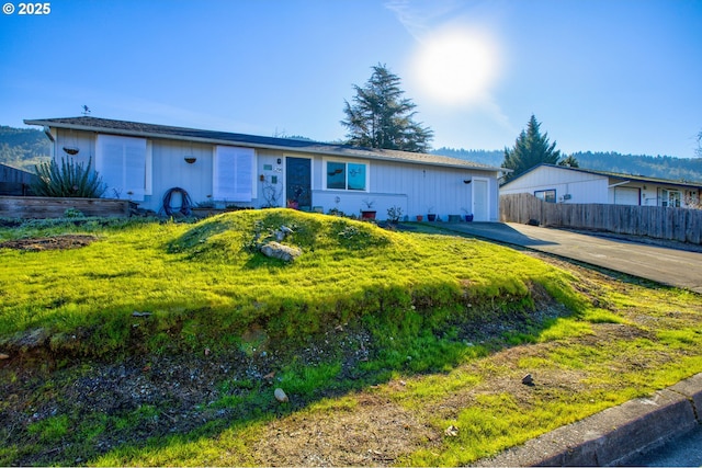 ranch-style home with a garage and a front lawn