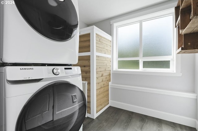 3660 Rocky Creek Ave, Depoe Bay, OR 97341 - laundry area featuring stacked washer / drying machine, dark wood-style flooring, baseboards, and wooden walls