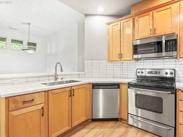 kitchen featuring decorative backsplash, sink, light wood-type flooring, and stainless steel appliances