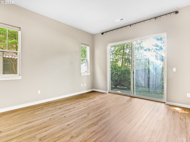 spare room with light hardwood / wood-style flooring and a healthy amount of sunlight