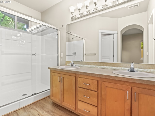 bathroom with hardwood / wood-style floors, vanity, and walk in shower