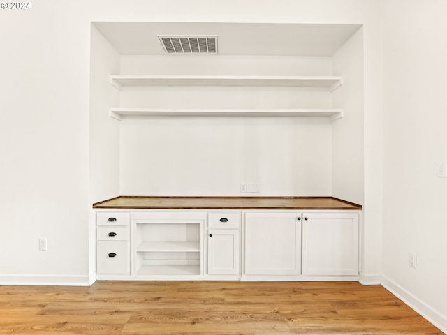 interior space with white cabinetry and light wood-type flooring