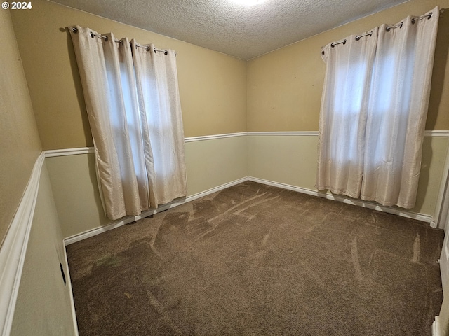 carpeted spare room with a textured ceiling