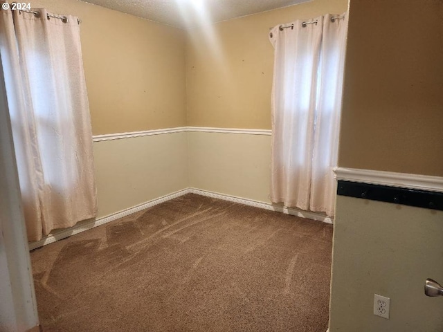 empty room with carpet flooring and a textured ceiling