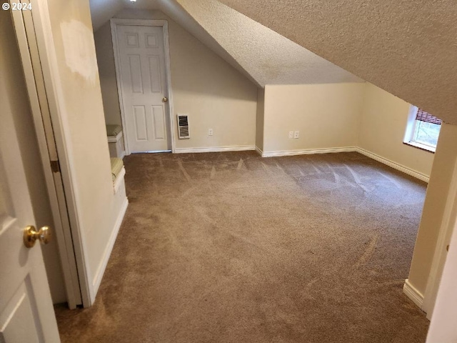 bonus room with lofted ceiling, a textured ceiling, and dark colored carpet