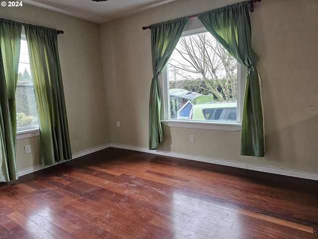 unfurnished room with hardwood / wood-style flooring and a healthy amount of sunlight