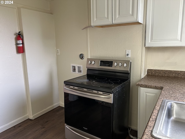 kitchen with white cabinetry, sink, stainless steel range with electric cooktop, and dark hardwood / wood-style floors