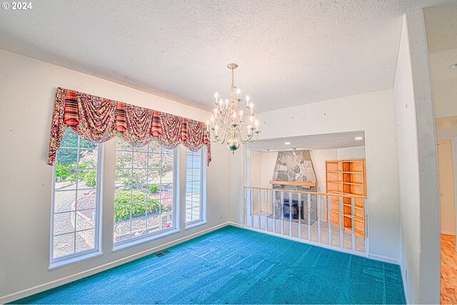 unfurnished living room with a textured ceiling, carpet floors, and a notable chandelier