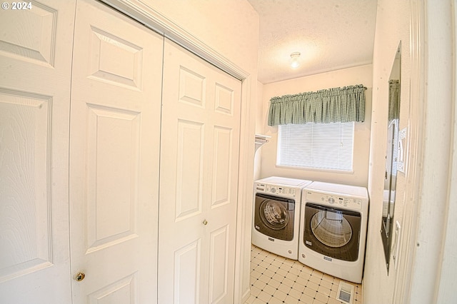 clothes washing area with a textured ceiling and washing machine and clothes dryer